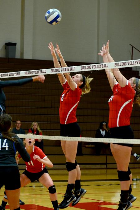 Mallory Baker, senior middle hitter, and Savannah Hughes, senior outside hitter, go up for a block against a Williams Baptist hit. - Photo by Meg Rushing