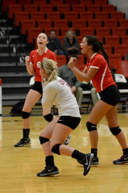 Mallory Baker, Courtney Masters and Elise Seufert celebrate a point in a match against Williams Baptist College. - Photo by Meg Rushing