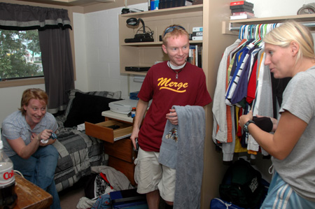 Freshman Brian Burns, with mother Connie and sister Heather, settles into his new home away from home in McAfee complex.  With farewells still to come laster in the afternoon, they stop to enjoy final laughs after a busy morning of moving in. - Photo by Lindsay Stavish