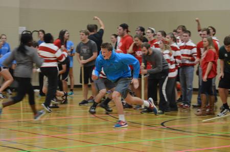 Avery Teague of Lambda Chi Alpha runs across the court in the dizzy bat race at Bulldog Olympics. - Photo by Meg Rushing