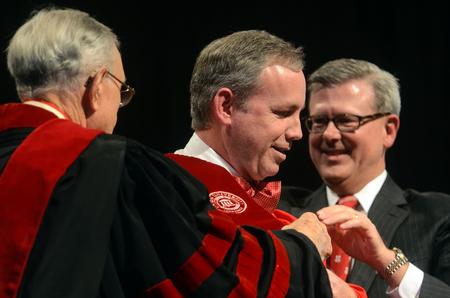 Hyran Barefoot, left, Union's 14th president, and Norman Hill, Board of Trustees Chair, right, aid in the hooding ceremony of Samuel W. "Dub" Oliver, middle, during Union's 16th presidential inauguration. - Photo by Kathleen Murray