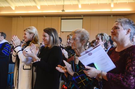 Dub Oliver's wife, daughter, mother and sister stand and clap following the inauguration ceremony. - Photo by Kathleen Murray