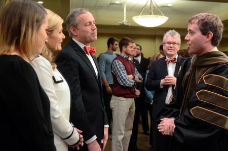 Dub Oliver and family greet Brad Spencer, assistant professor of pharmacy practice, during the reception following the inauguration. - Photo by Kathleen Murray