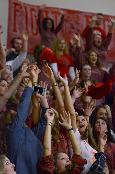 Students reach excitedly for free t-shirts that are tossed into the crowd during the Homecoming game. - Photo by Emily Stookey