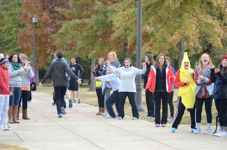 Members of Chi Omega cheer on runners as they cross the finish line at the Make-a-Wish 5K during homecoming. - Photo by Meg Rushing
