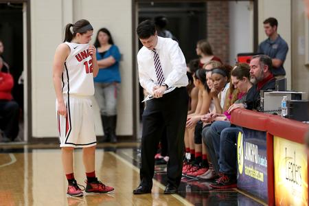 Mark Campbell, head coach, goes over some plays with Kelsey Risner during a foul shot on the other end of the court. - Photo by Kristi McMurry Woody
