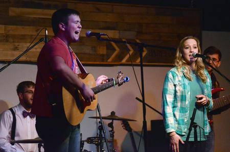 Cameron Skonhovd, freshman psychology major, and Savannah Legan, freshman nursing major, perform with David Key, freshman, on drums and Matt Battistelli, sophomore TESL major, on bass during Open Mic in Barefoots. - Photo by MiKalla Cotton