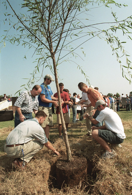 Students, faculty and staff remove the stones
surrounding the memorial tree. - Photo by Jim Veneman