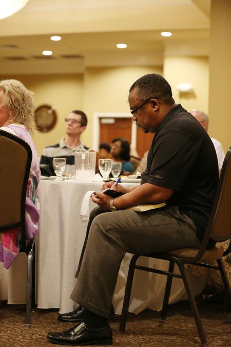 A guest of the "Toxic Charity: Compassion, Justice, and the Christian Life" conference takes notes as Bob Lupton speaks. - Photo by Kristi McMurry Woody