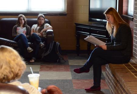 Alexis Piscatello, senior music major, reads her pieces during the English portion of the Scholarship Symposium in the fireplace room of the Bowld Student Commons.  - Photo by MiKalla Cotton