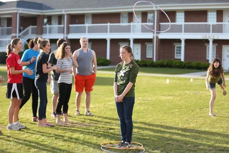 Students participate in a game where one member of a team must toss three hula hoops onto a teammate during Field Day hosted by Residence Life.  - Photo by Kristi McMurry Woody