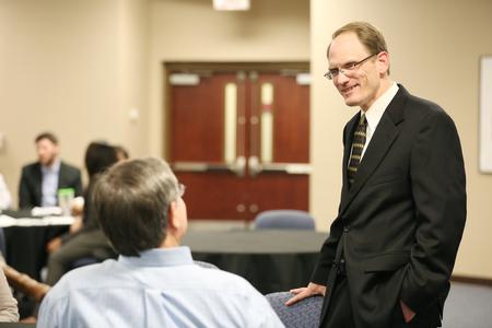 Kevin Westbrook, professor of marketing, chats with a student before an evening of group presentations in the MBA program. - Photo by Kristi McMurry Woody