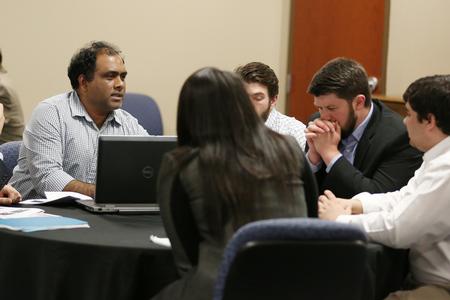 A group of students goes over their presentation materials prior to making a presentation to a local non-profit as part of the MBA program. - Photo by Kristi McMurry Woody