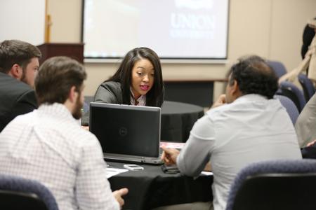 Students go over their work for a non-profit before presenting at the end of their MBA studies.  - Photo by Kristi McMurry Woody