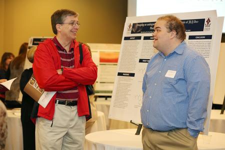 Randy Johnston, university professor of chemistry and department chair, chats with Tyler Smith, senior biochemistry major, about his final research project at the Scholarship Symposium poster sessions. - Photo by Kristi McMurry Woody