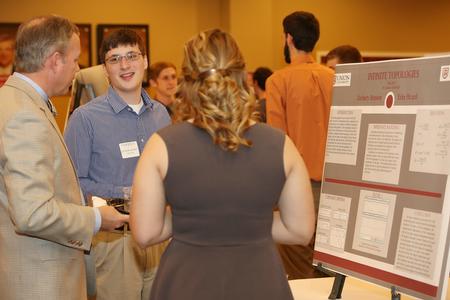 Zachary Benson, junior engineering major, discusses his poster presentation with Dub Oliver (left), president of the university, during the Scholarship Symposium. - Photo by Kristi McMurry Woody