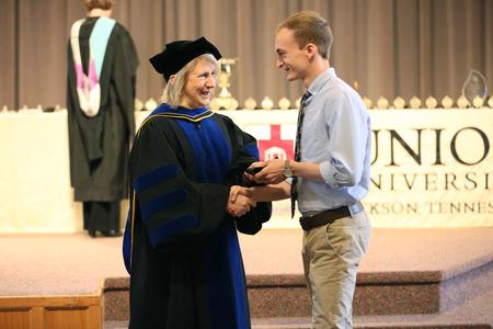 Jeannette Russ, professor of engineering and department chair, awards Matt Bentley, senior engineering major, with the academic excellence medal in engineering. - Photo by Kristi McMurry Woody