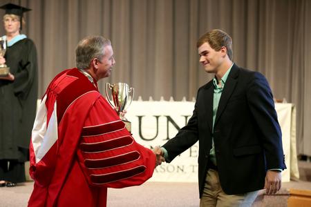 Dub Oliver, president of the university, presents the men of Lambda Chi Alpha with the Greek Scholarship cup at Awards Day. - Photo by Kristi McMurry Woody