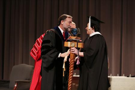 Hal Poe hands over the mace to the new faculty member of the year, Ashley Blair, assistant professor of communication arts.  - Photo by Kristi McMurry Woody