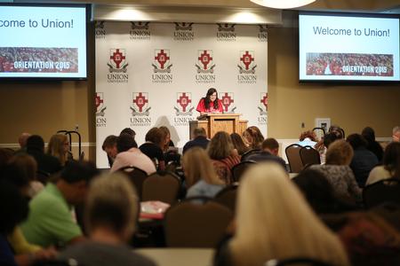 Mallory Lamm, sophomore social work major, prays over new students at their Summer Orientation. - Photo by Kristi McMurry Woody