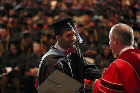 Matthew Marshall, master of education graduate, accepts his diploma from Dub Oliver, president of the university. - Photo by Amanda Rohde