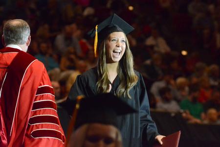 Katie Longworth, nursing graduate, excitedly walks off the stage after receiving her diploma at the Spring Commencement Services. - Photo by Emily Stookey