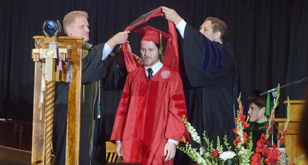 Austin Michael Camp, Doctor of Pharmacy graduate, receives his hood at spring graduation. - Photo by Elizabeth Wilson