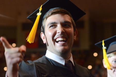 Blake Norton, psychology graduate, gives a smile to some friends in the audience as he goes up to the stage.  - Photo by Elizabeth Wilson