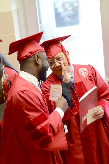 Charlie Lee (right), doctor of ministry graduate and recipient of the first degree from the Singapore program, jokes with a fellow graduate before the spring commencement services begin. - Photo by David Parks