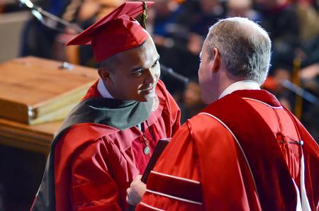 A School of Pharmacy graduate receives his degree from Dub Oliver, president of the university, during the spring commencement services. - Photo by David Parks