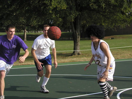 Joey Ashby, Bobby Ludwig & an afroed Katie Woodruff zero in on the ball during the Faculty/Staff vs. Student game at the dedication of the Class of 2002 Basketball Court. - Photo by Cam Tracy