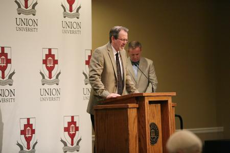 John Netland, professor of English, prays at the beginning of a reception honoring retiring faculty. - Photo by Kristi McMurry Woody