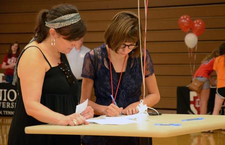 Abi Brown, freshman, and her mother Linda Brown complete forms on new student move-in day in the Fred DeLay Gym. - Photo by Elizabeth Wilson