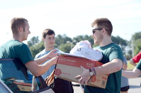 Student leaders Joshua Edgren, senior physics major, Benton Hurt, junior cell and molecular biology major, and Joshua Stephens, senior digital media studies major, help on new student move-in day. - Photo by David Parks