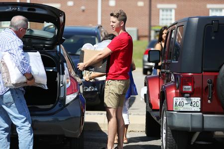 Joseph Smith, senior business administration major, helps out a family on new student move-in day. - Photo by Kristi McMurry Woody