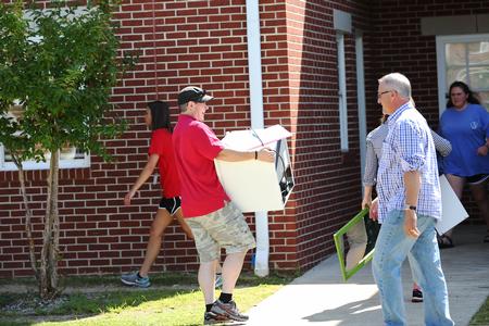 Web Drake, associate professor of communication arts and department chair, helps a new student on move-in day. - Photo by Kristi McMurry Woody