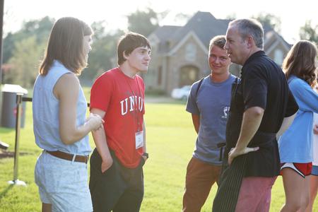 Dub Oliver (right), president of the university, chats with students at his home during Welcome Week. - Photo by Kristi McMurry Woody