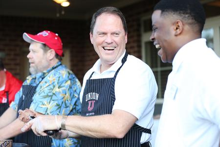 Gary Carter, senior vice president for business services, scoops ice cream at the Welcome Week ice cream party held at the president's home. - Photo by Kristi McMurry Woody
