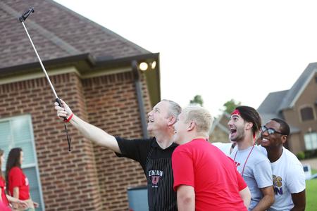Dub Oliver, president of the university, takes a selfie with students during the Welcome Week ice cream party at his home. - Photo by Kristi McMurry Woody