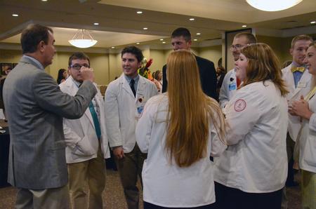 David Kuhl, Baptist Memorial Healthcare professor of pharmacy, chats with new pharmacy students during a reception held after the White Coat Ceremony. - Photo by MiKalla Cotton