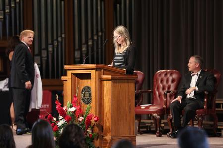Kim Jones, assistant dean of the School of Pharmacy, calls the name of each member of the class of 2019 as they cross the stage to receive a white coat. - Photo by Kristi McMurry Woody