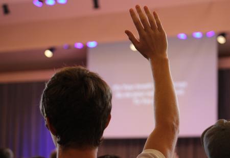 A student raises his hand to glorify God during worship in chapel. - Photo by Sol Bee Park