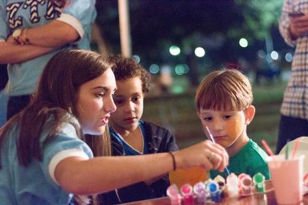 Children are fascinated as Hannah Richardson, senior cell and molecular biology major, paints faces at the Zeta Tau Alpha booth during Union Night. - Photo by David Parks