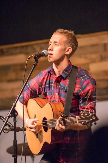 Zachary Lancaster, senior art major, shows the audience an original piece for Open Mic Night in Barefoots Joe. - Photo by David Parks