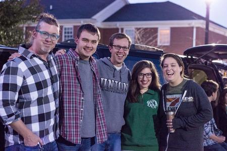 Cardinal & Cream staff surround Eric Marcy, senior English major (middle), as everyone poses for a photo during Trunk or Treat. - Photo by David Parks