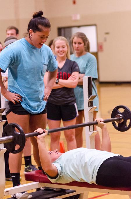 Taylor Gore, senior family studies major, spots Rebecca Shamblin, senior family studies major, in the bench press challenge during the Union's Fittest Team competition. - Photo by David Parks
