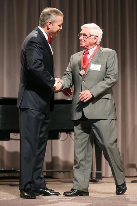 Ned Boston, class of 1966, shakes hands with Dub Oliver, president of the university, after receiving his 50 year medallion at Homecoming chapel. - Photo by Kristi McMurry Woody