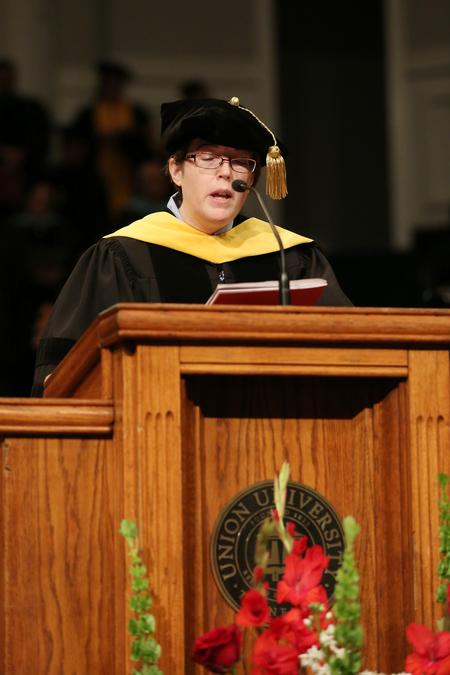 Beth Madison, assistant professor of science in the department of continuing studies, reads scripture during the second fall commencement service.  - Photo by Kristi McMurry Woody