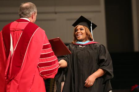 Graduates walk across the stage at fall commencement services to receive their degrees.  - Photo by Kristi McMurry Woody