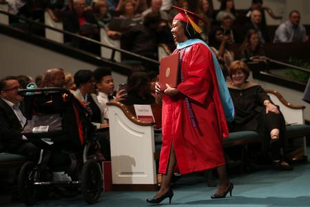 Lakishia Robinson, doctor of education graduate, walks back to her seat after receiving her degree at fall commencement services.  - Photo by Kristi McMurry Woody